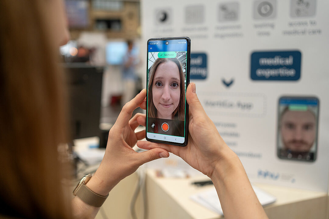 Blick über die Schulter auf ein Smartphone Display Applikation im Selfie-Modus